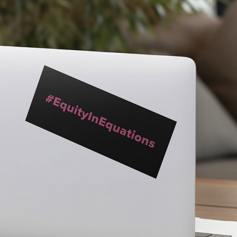 Rectangular sticker on laptop with hashtag "#EquityinEquations" with pink text on a black background